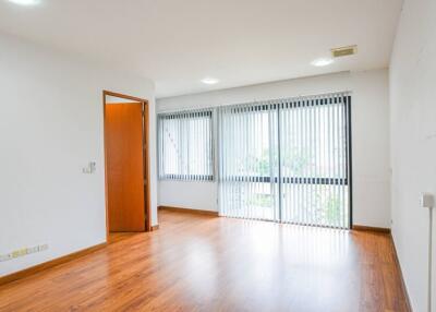 Spacious living room with large windows and wooden flooring