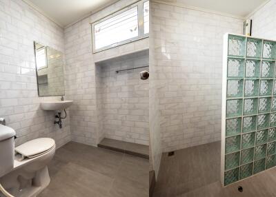 Modern bathroom with tiled walls and glass partition