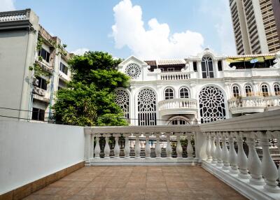 View of a terrace with decorative railing and buildings in the background