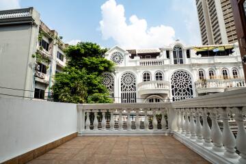 View of a terrace with decorative railing and buildings in the background