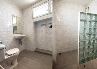 Modern bathroom with tiled walls and glass-block shower