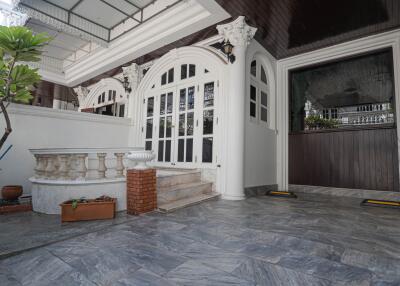 Exterior view showcasing the entrance with double glass doors, decorative railings, and tile flooring