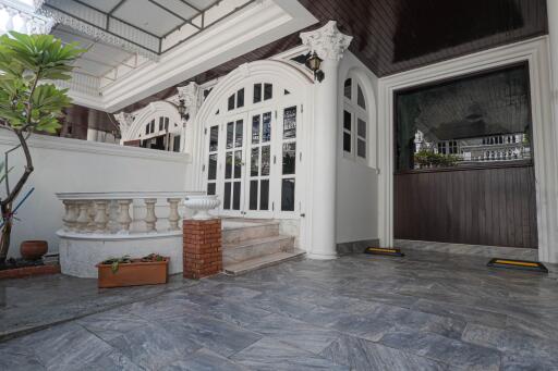 Exterior view showcasing the entrance with double glass doors, decorative railings, and tile flooring