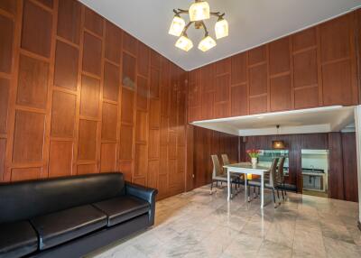 Spacious living and dining area with wooden panel walls