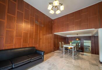 Spacious living and dining area with wooden panel walls