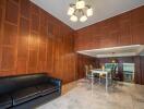 Spacious living and dining area with wooden panel walls