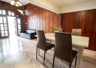 Modern dining area with wooden paneling and marble floor