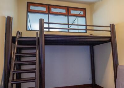 Bedroom with loft area and wooden flooring