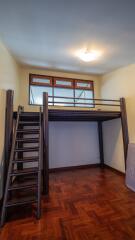 Bedroom with loft area and wooden flooring