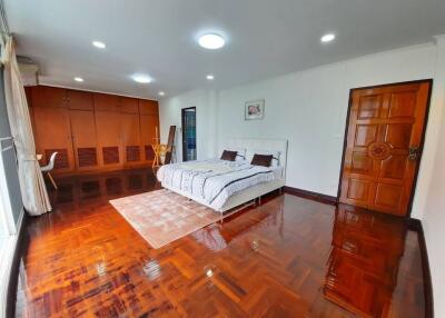 Spacious bedroom with hardwood floor and large windows