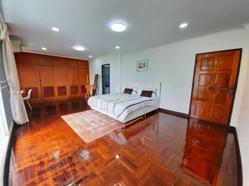 Spacious bedroom with hardwood floor and large windows