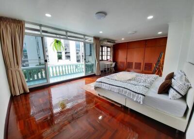 Spacious bedroom with balcony and hardwood floors