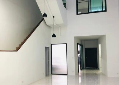 Spacious main living area with high ceilings and modern lighting.