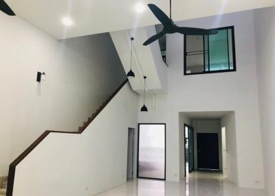 Modern living room with high ceiling and ceiling fans