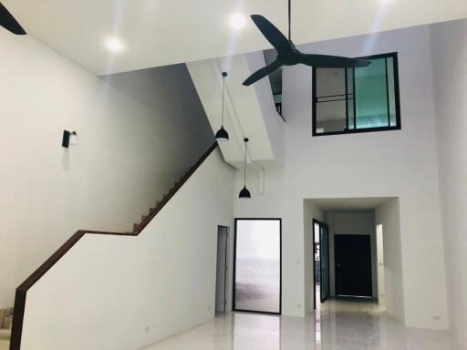 Modern living room with high ceiling and ceiling fans