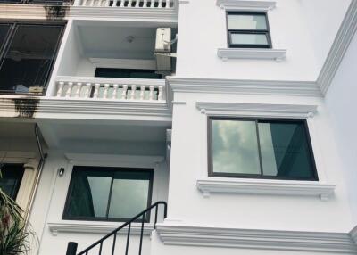 Exterior view of a residential building with multiple balconies and a spiral staircase