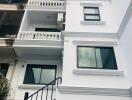 Exterior view of a residential building with multiple balconies and a spiral staircase