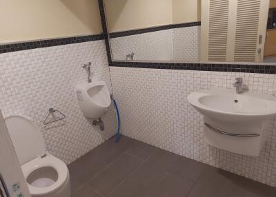 Clean bathroom with urinal, toilet, and sink