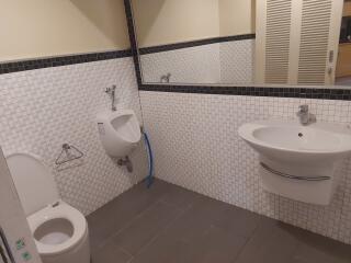 Clean bathroom with urinal, toilet, and sink