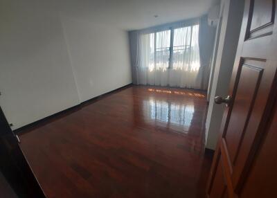 Empty bedroom with wooden floor and large window