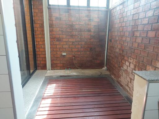 Covered laundry area with tiled walls