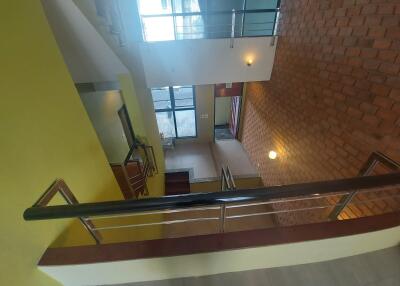 Staircase with railing and brick wall accents