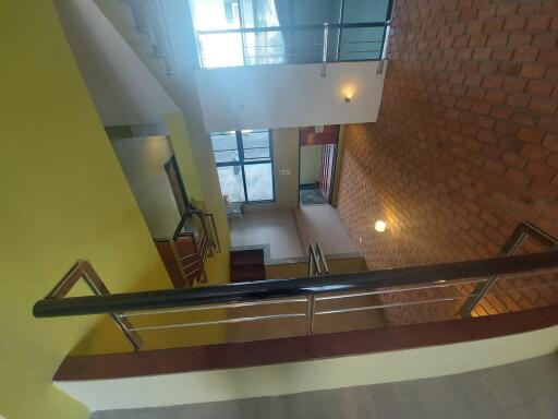 Staircase with railing and brick wall accents