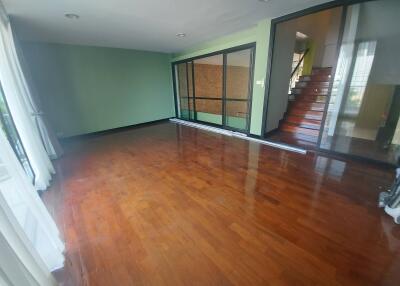 Spacious living room with polished wooden floors and large windows