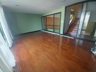 Spacious living room with polished wooden floors and large windows