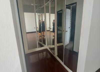 Hallway with wooden floor and mirrored closets