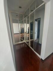 Hallway with wooden floor and mirrored closets