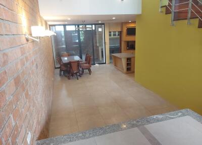 Spacious dining area with brick accent wall and modern lighting