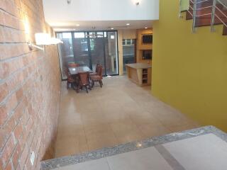 Spacious dining area with brick accent wall and modern lighting