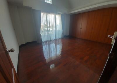 Spacious bedroom with wooden floor and built-in closets