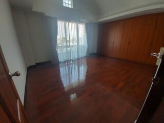 Spacious bedroom with wooden floor and built-in closets