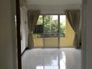 Bright living room with large windows and tiled floor