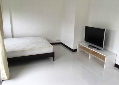 Simple bedroom with a bed and a TV