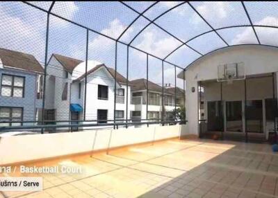 Outdoor basketball court with roof and netted surrounding