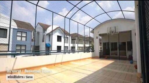 Outdoor basketball court with roof and netted surrounding