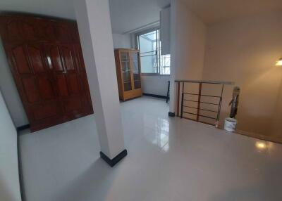 Hallway area with cabinets and railing