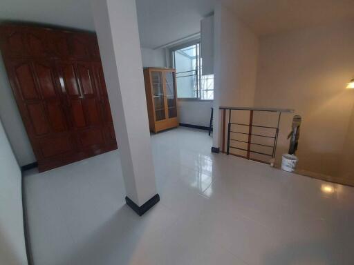 Hallway area with cabinets and railing