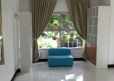 Well-lit living room with large windows and modern furniture