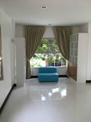 Well-lit living room with large windows and modern furniture