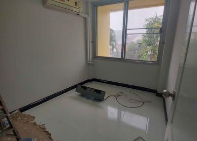 Small bedroom with a window and air conditioning unit