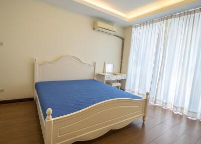 Bedroom with wooden floor and white furniture