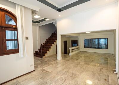 Spacious living area with large windows and staircase