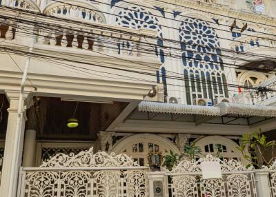 Exterior view of a multi-story building with ornate balconies and decorative gates