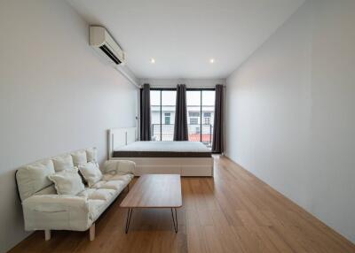 Minimalist bedroom with bed, sofa, and large windows