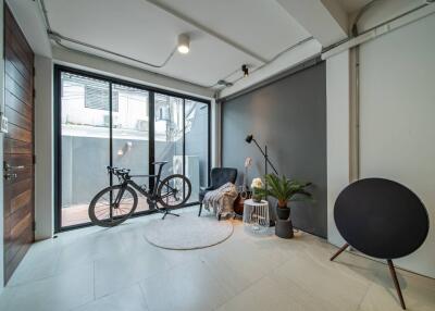 Modern living room with large windows, plants, and a bicycle