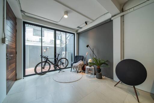 Modern living room with large windows, plants, and a bicycle